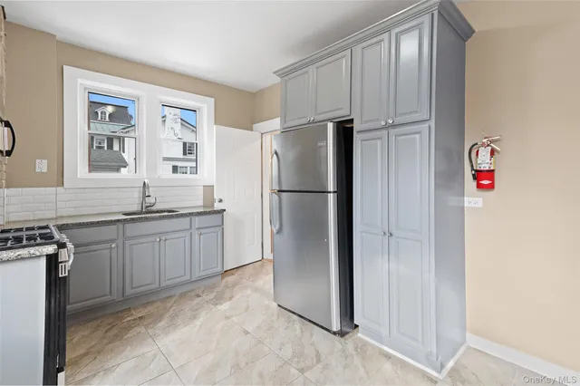 a kitchen with stainless steel appliances granite countertop a refrigerator sink and stove