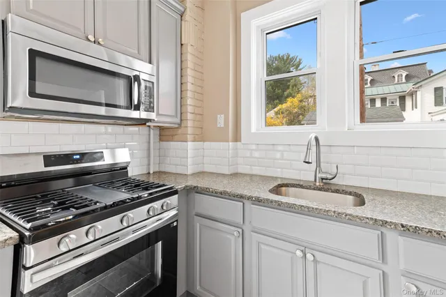 a kitchen with granite countertop cabinets stainless steel appliances and a sink
