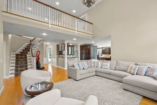 a living room with furniture kitchen view and a chandelier