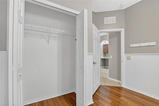 an empty room with windows and fan