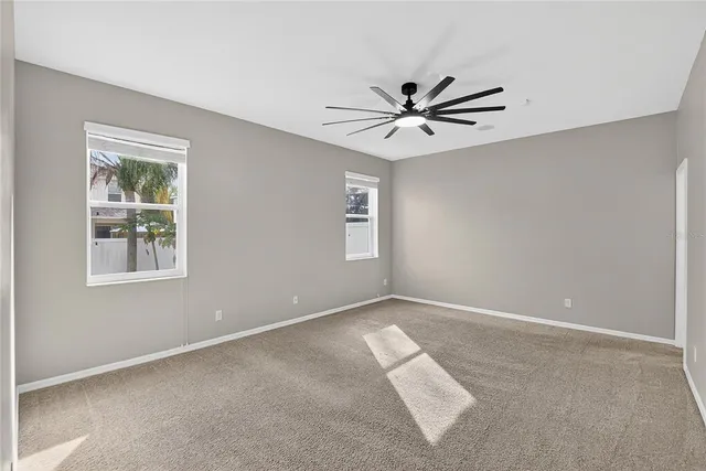 an empty room with a window and a fan