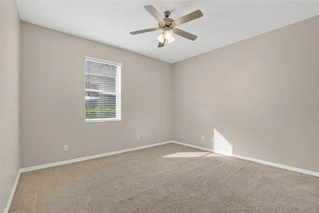 a view of backyard with large tree and wooden fence