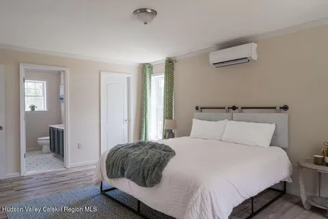 a bedroom with a large bed and wooden floor