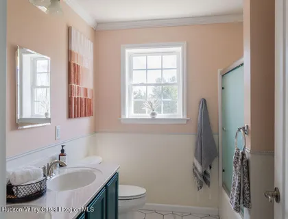a bathroom with a sink toilet and window