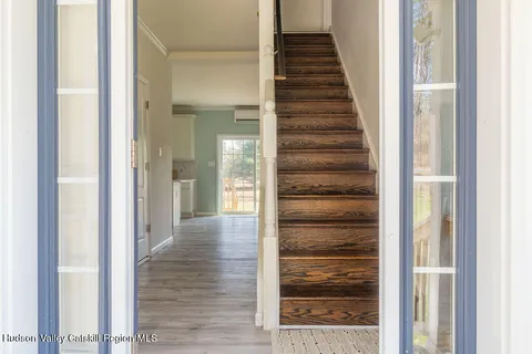 a view of a hallway with wooden floor and windows