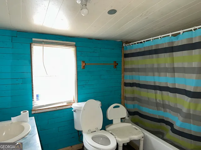 a bathroom with a sink mirror vanity and toilet