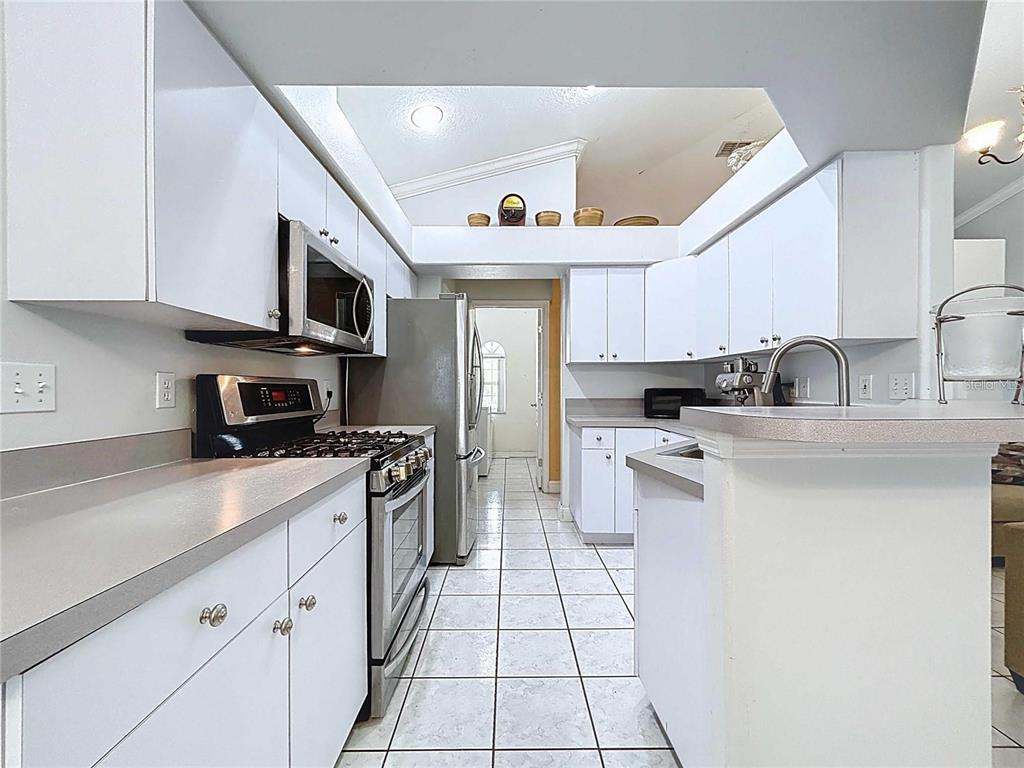 3324 West Abdella Street Tampa, FL 33607 - Photo 9 of 20 a kitchen with stainless steel appliances granite countertop a sink and dishwasher a stove top oven with white cabinets