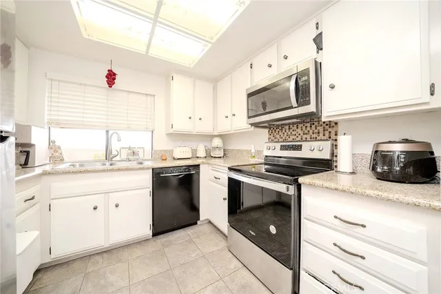 a kitchen with stainless steel appliances granite countertop a sink and a stove