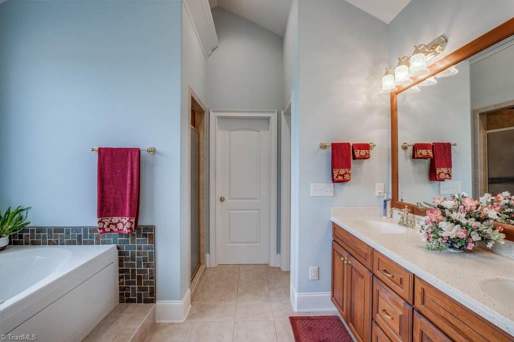 190 Baltimore Downs Road Advance, NC 27006 - Photo 13 of 30 Tile floor, jetted tub with decorative tile backsplash and custom shelving in walk-in closet