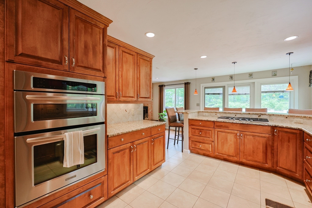 10 Grover Road Ashland, MA 01721 - Photo 28 of 41 a kitchen with stainless steel appliances granite countertop wooden cabinets a stove a sink and dishwasher with wooden floor