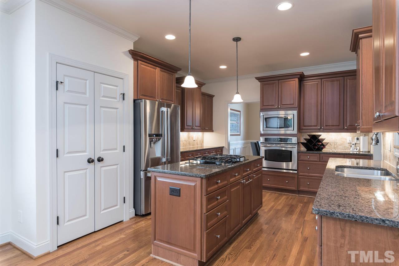 11511 Azari Court Raleigh, NC 27614 - Photo 8 of 25 a kitchen with stainless steel appliances granite countertop a stove refrigerator and a wooden floor