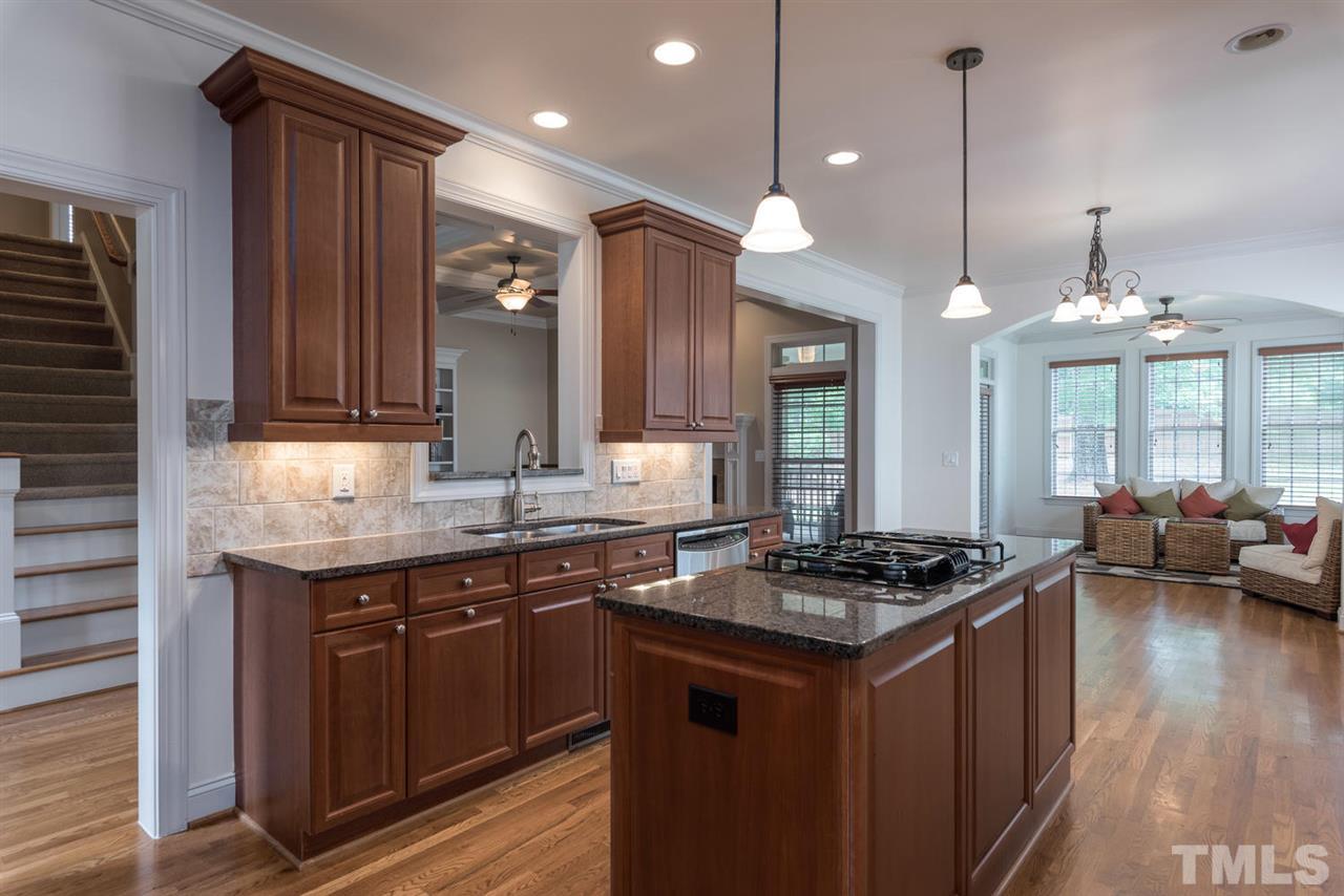 11511 Azari Court Raleigh, NC 27614 - Photo 10 of 25 a kitchen with granite countertop a sink stove and cabinets