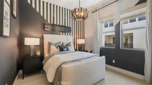 a bedroom with a bed and a chandelier