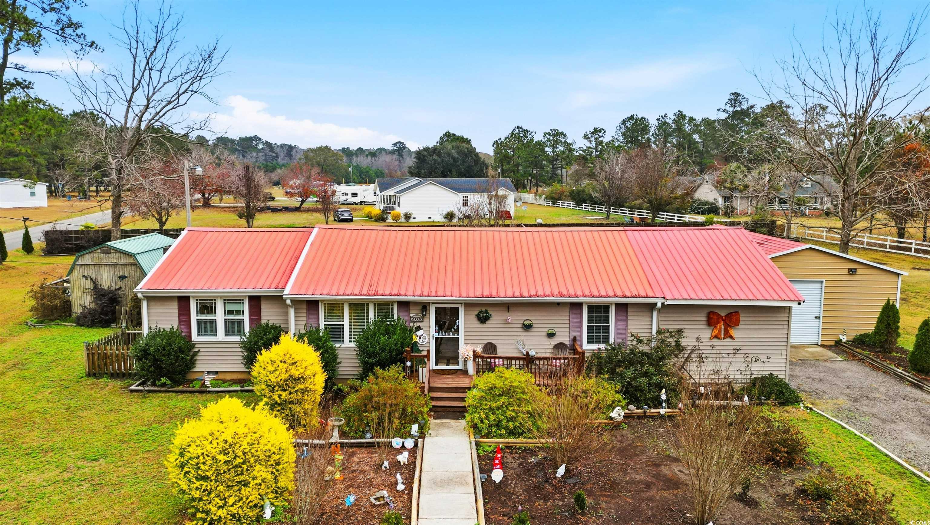 Ranch-style home featuring a metal roof, an outbuilding, driveway, and a garage
