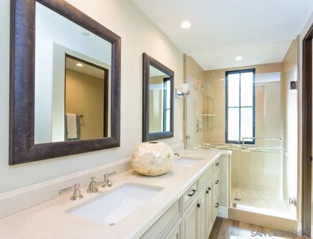 a bathroom with double vanity sinks and a mirror