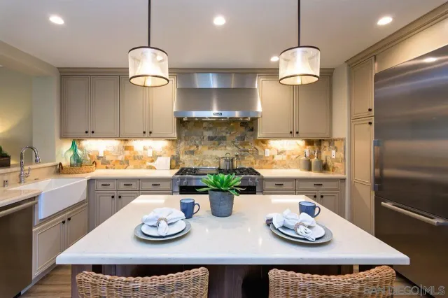 a kitchen with stainless steel appliances granite countertop a refrigerator and a stove top oven