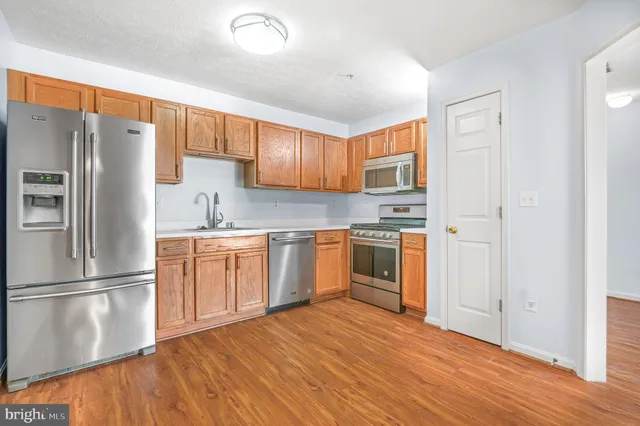 a kitchen with granite countertop a refrigerator stove top oven and sink