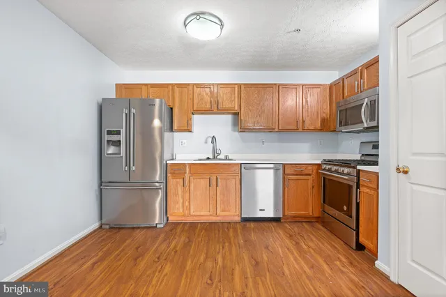 a kitchen with granite countertop a refrigerator stove and sink