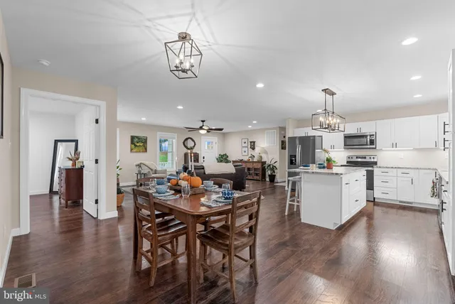 a view of a dining room and livingroom with furniture wooden floor a chandelier