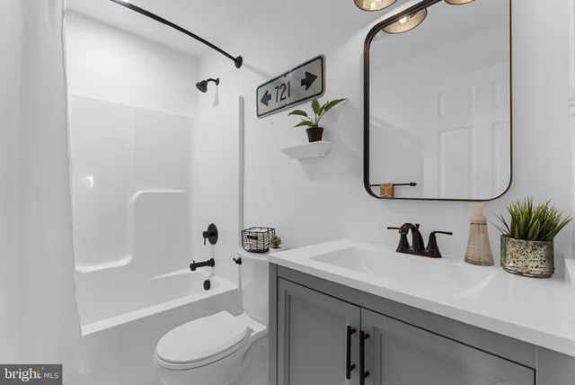 a bathroom with a sink a toilet and shower curtain