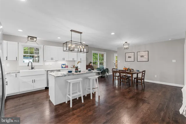 a kitchen with a dining table chairs wooden floor and appliances