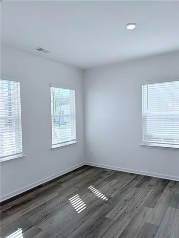 a large white kitchen with kitchen island a sink wooden floor and stainless steel appliances