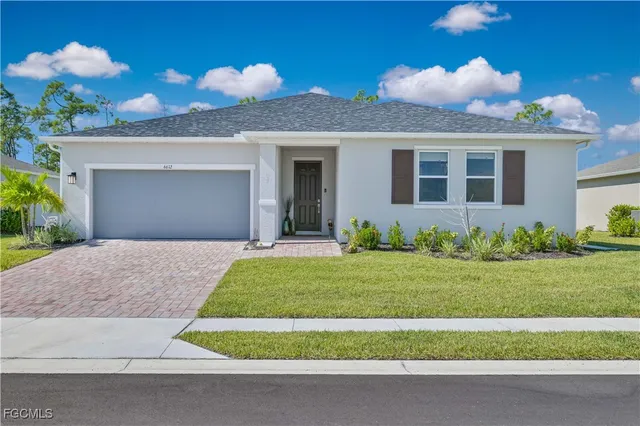 a front view of a house with a yard and a garage