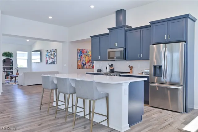 a kitchen with kitchen island wooden floors and living room