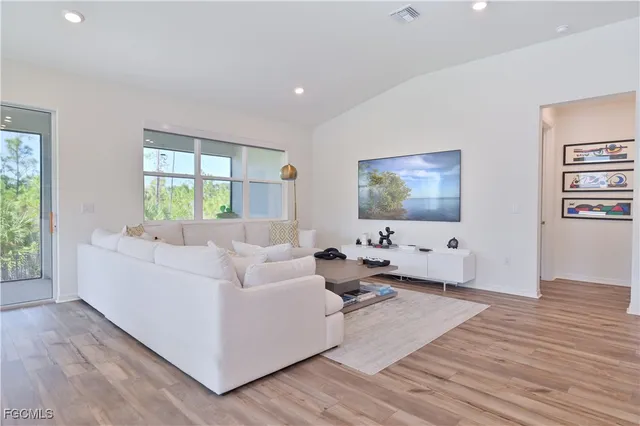 a living room with furniture and a dining table with kitchen view
