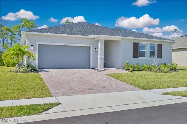 a front view of a house with a yard and a garage