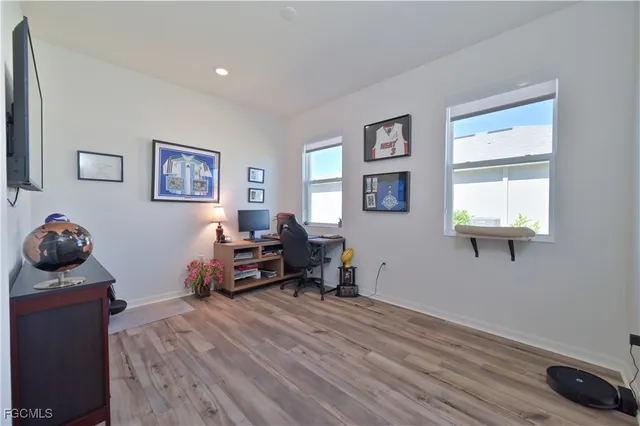 a view of a workspace with wooden floor and furniture