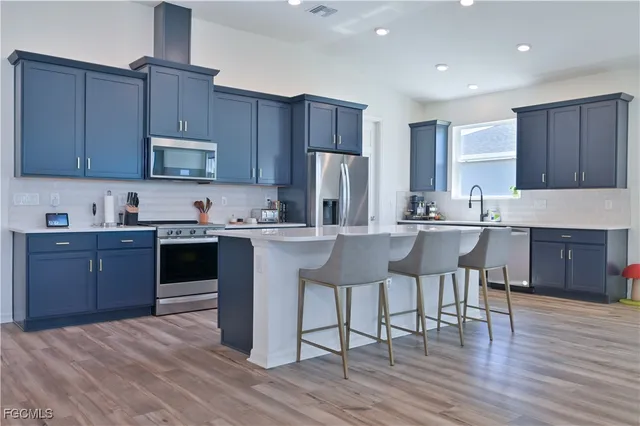 a kitchen with stainless steel appliances granite countertop a stove microwave refrigerator and sink