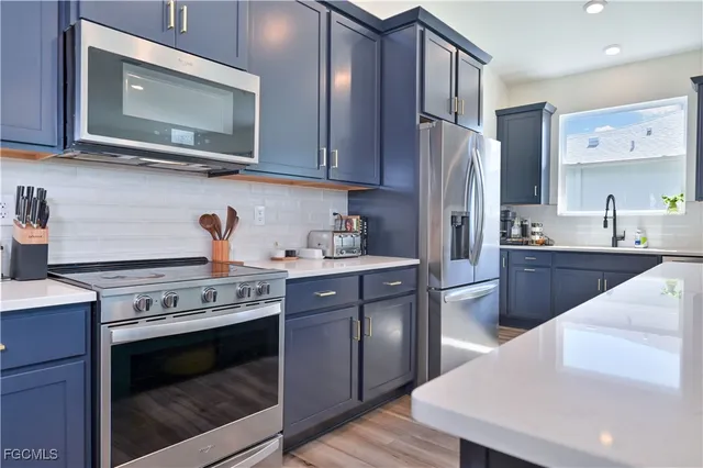 a living room with couches and kitchen view with wooden floor
