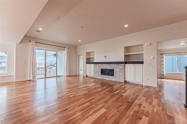 a view of empty room with wooden floor and fireplace