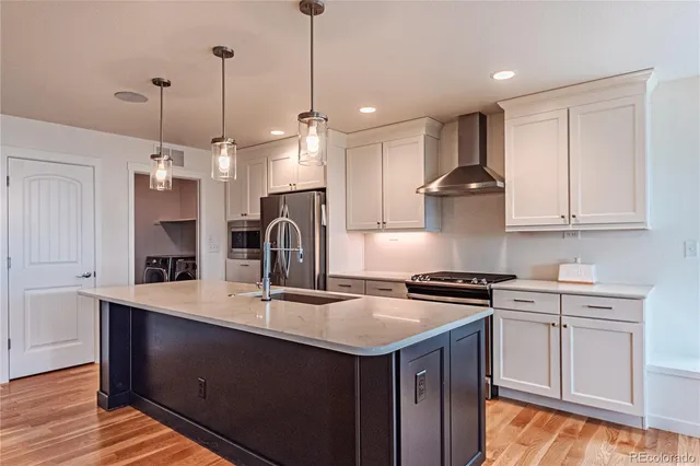 a kitchen with a sink a stove a refrigerator and cabinets