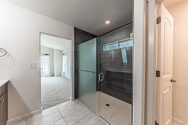 a bathroom with a glass shower door and a mirror