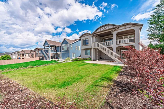 a view of house with garden and tall trees