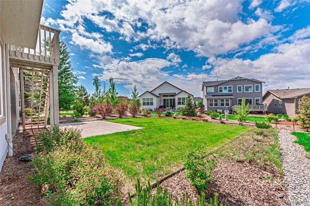 a view of a big house with a big yard and large trees