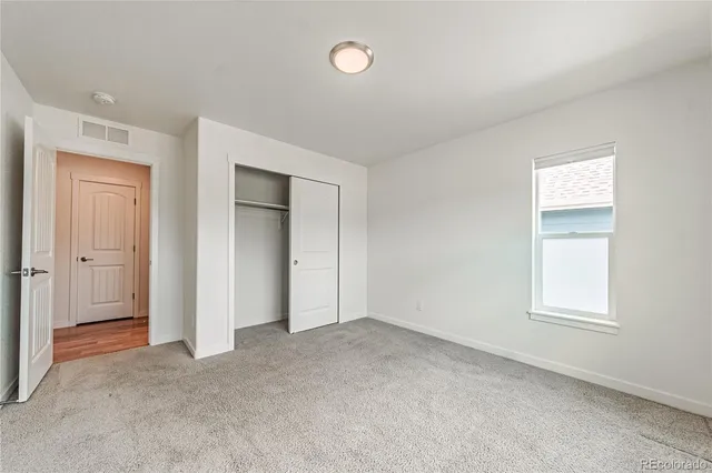 an empty room with windows and closet