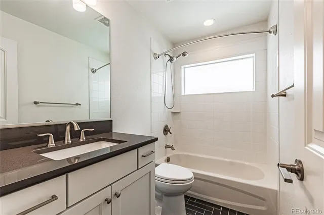 a bathroom with a granite countertop sink toilet and shower