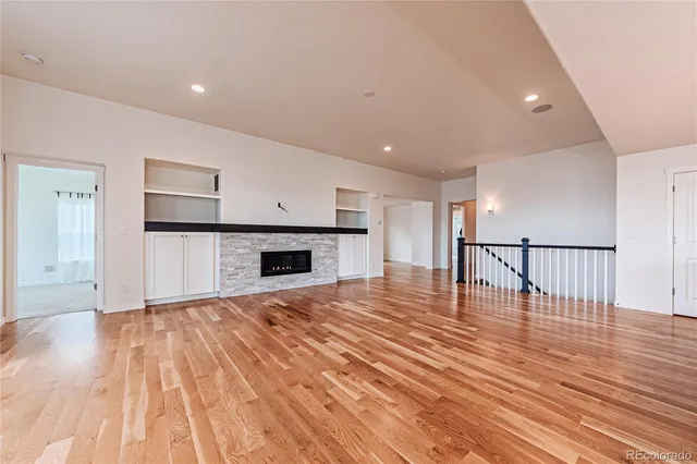 a view of empty room with wooden floor and fireplace