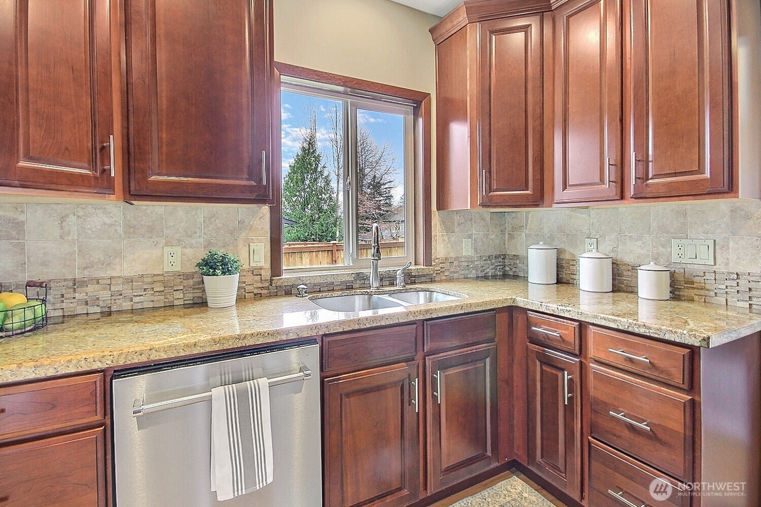 21834 Southeast 265th Way Maple Valley, WA 98038 - Photo 12 of 31 a kitchen with stainless steel appliances granite countertop wooden cabinets a sink and dishwasher next to a window