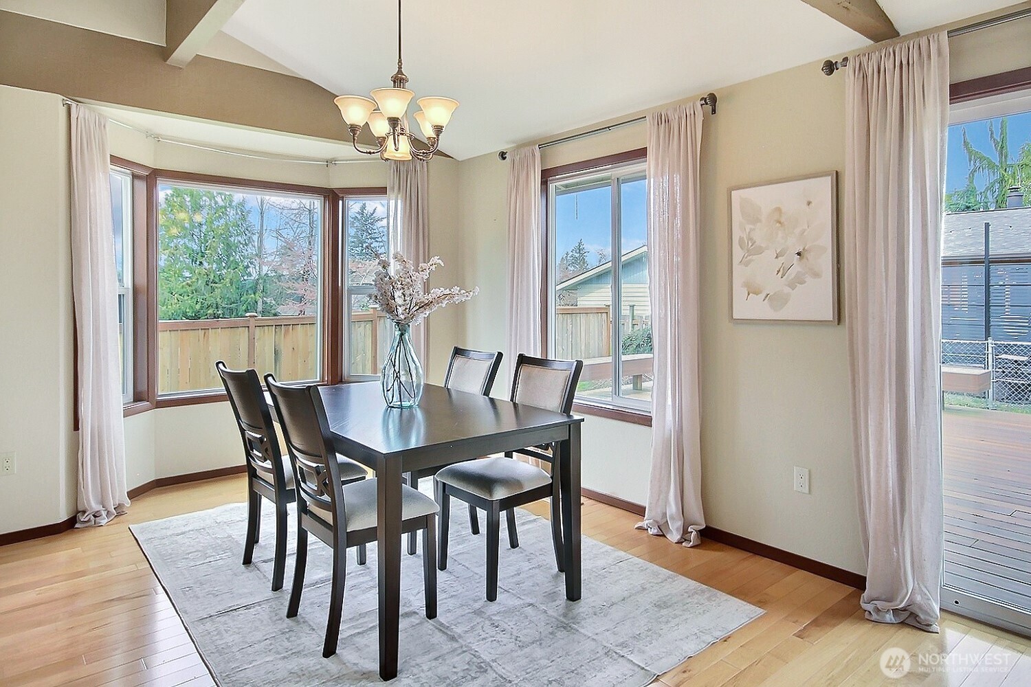 21834 Southeast 265th Way Maple Valley, WA 98038 - Photo 13 of 31 a view of a dining room with furniture a chandelier and wooden floor
