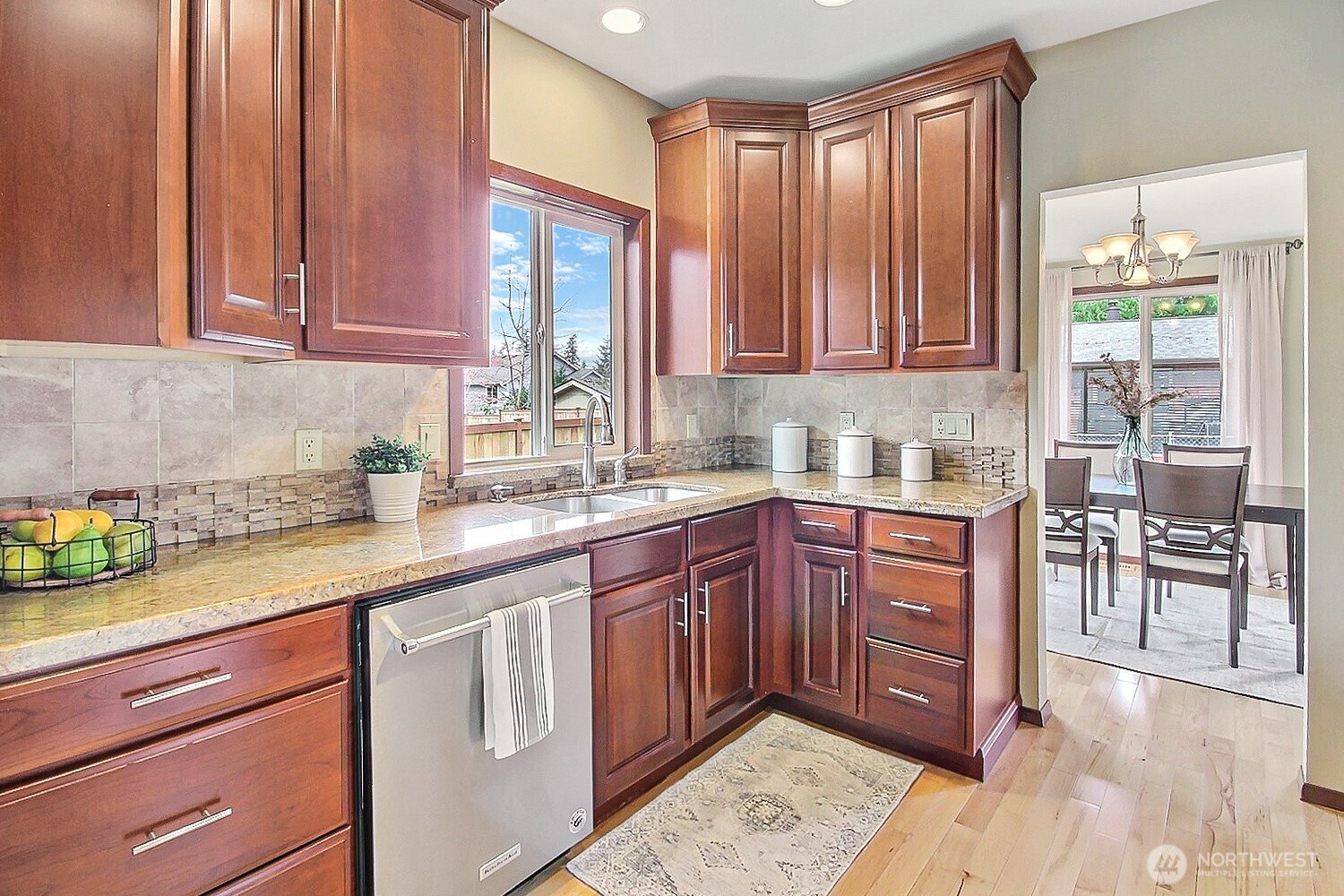 21834 Southeast 265th Way Maple Valley, WA 98038 - Photo 8 of 31 a kitchen with stainless steel appliances granite countertop wooden cabinets a sink and dishwasher with a large window
