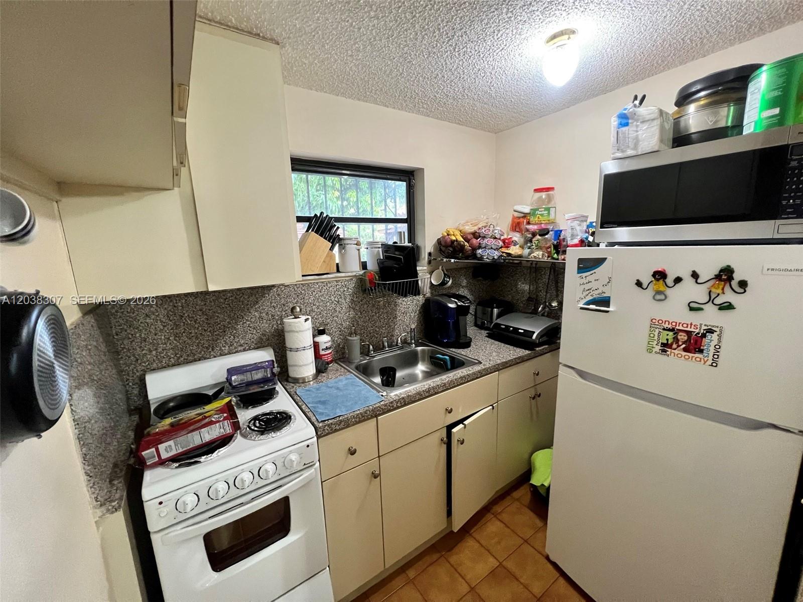 9601 Southwest 66th Street Miami, FL 33173 - Photo 45 of 62 a kitchen with a stove and a microwave