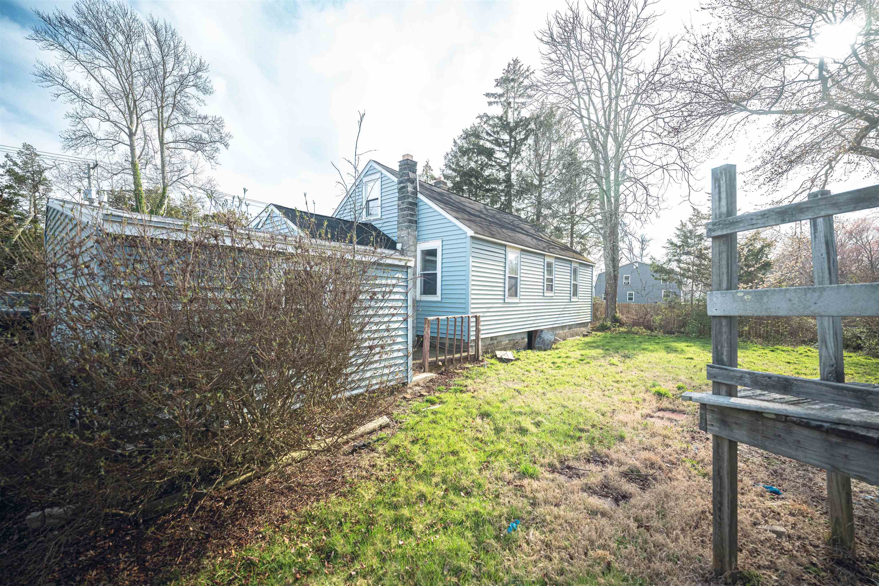 768 Seashore Road Cape May, NJ 08204 - Photo 5 of 12 a backyard of a house with large trees and wooden fence