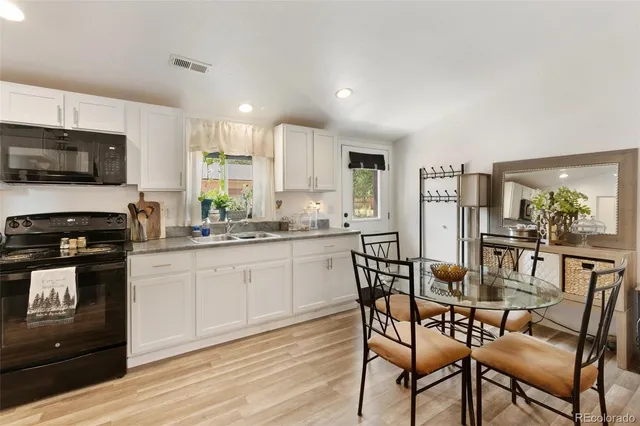 a kitchen with a table chairs microwave and cabinets