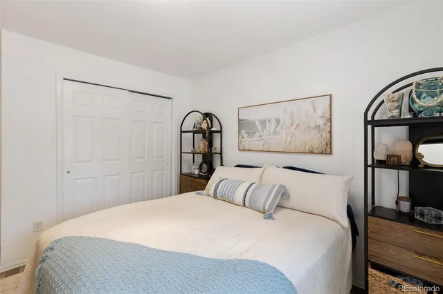 a bedroom with a large bed and a painting on the wall