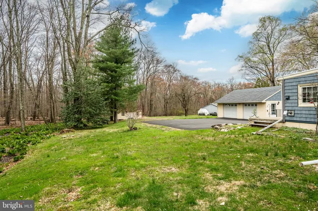 a backyard of a house with lots of green space and wooden fence