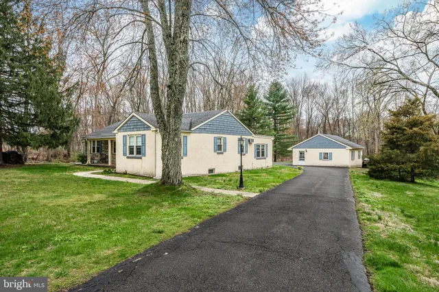 a front view of a house with a yard and trees
